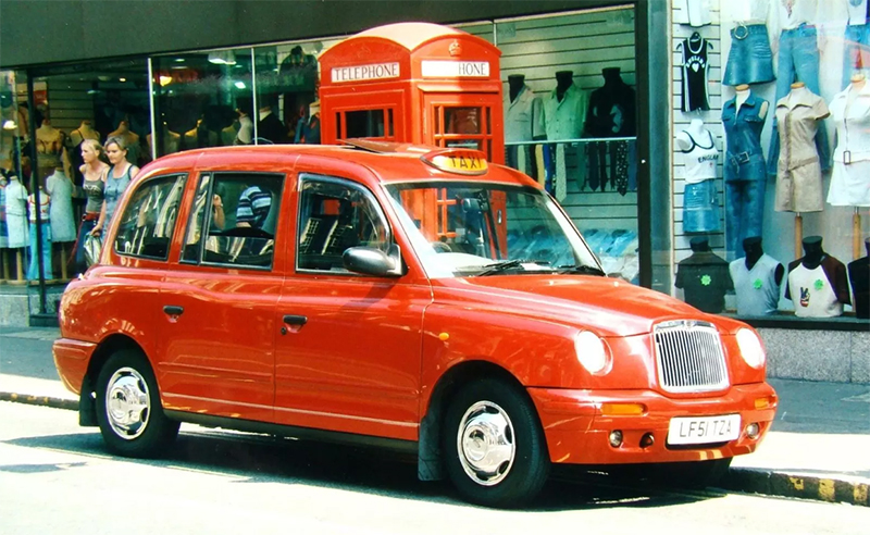 Эффектный лондонский автомобиль-такси LTI TX1 рядом с легендарной телефонной будкой. 1998 год.